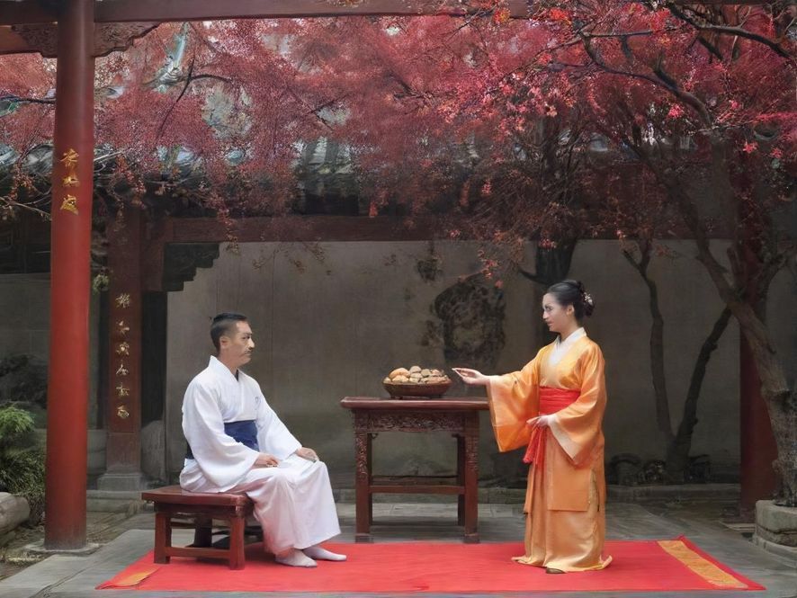 一个布置奢华的私人包厢,暖色调的灯光营造出温馨私密的氛围,柔软的沙发,精致的茶几上摆放着高品质的饮品和点心,显示出高端休闲会所的格调。